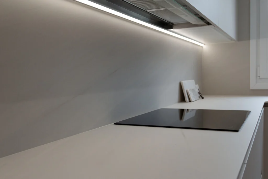 Cocina reformada con muebles blancos y encimera clara
